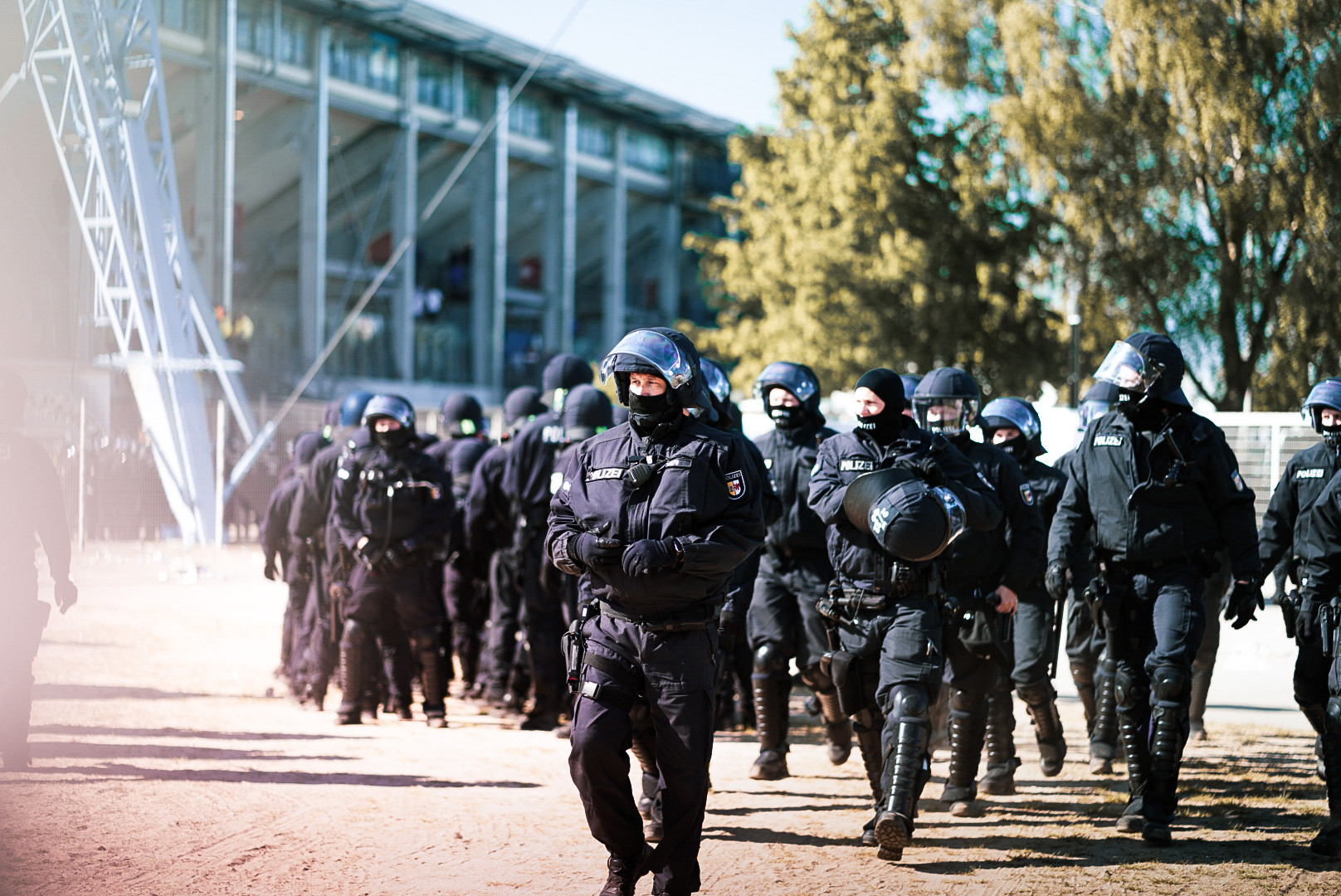 Polizeibeamte in Einsatzuniform vor einem Fußballstadion